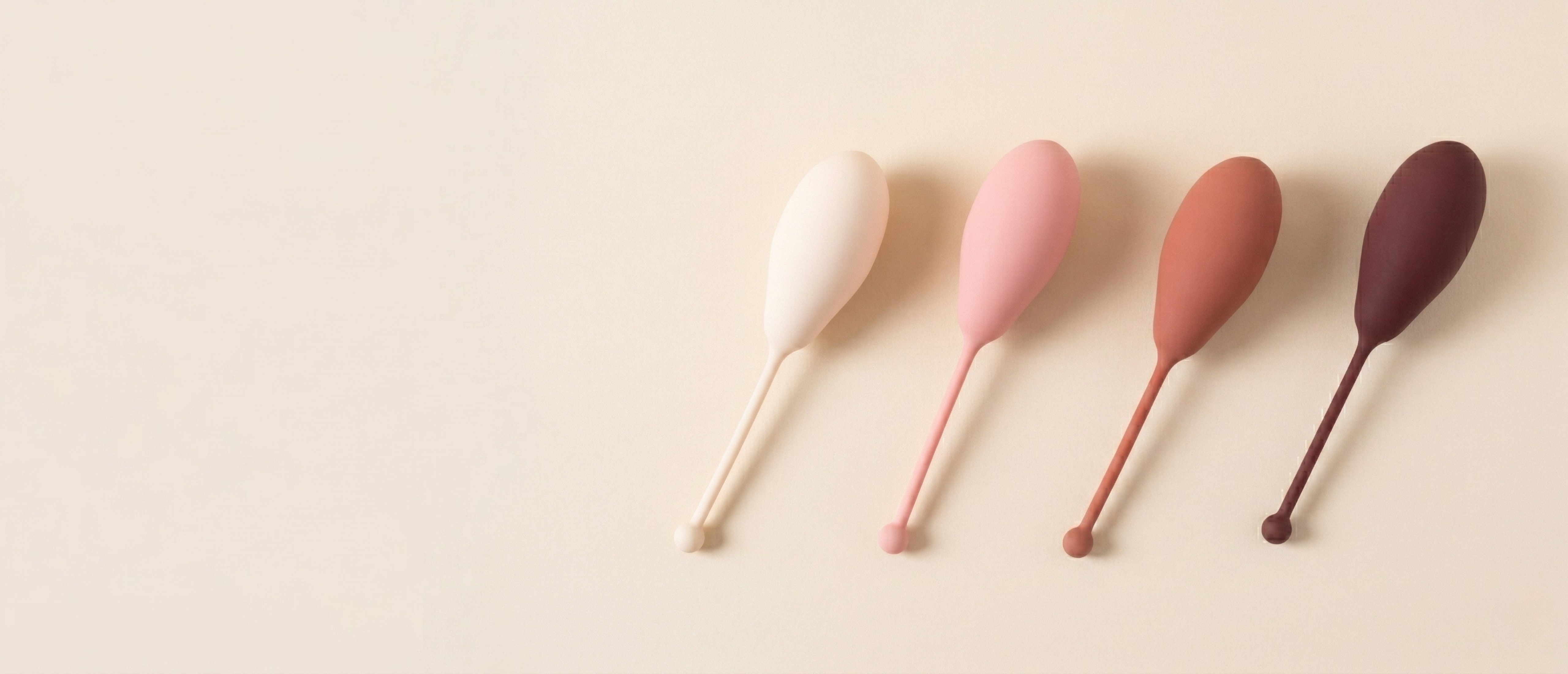 The Toner — four progressive kegel weights, graduated light to dark on cream background